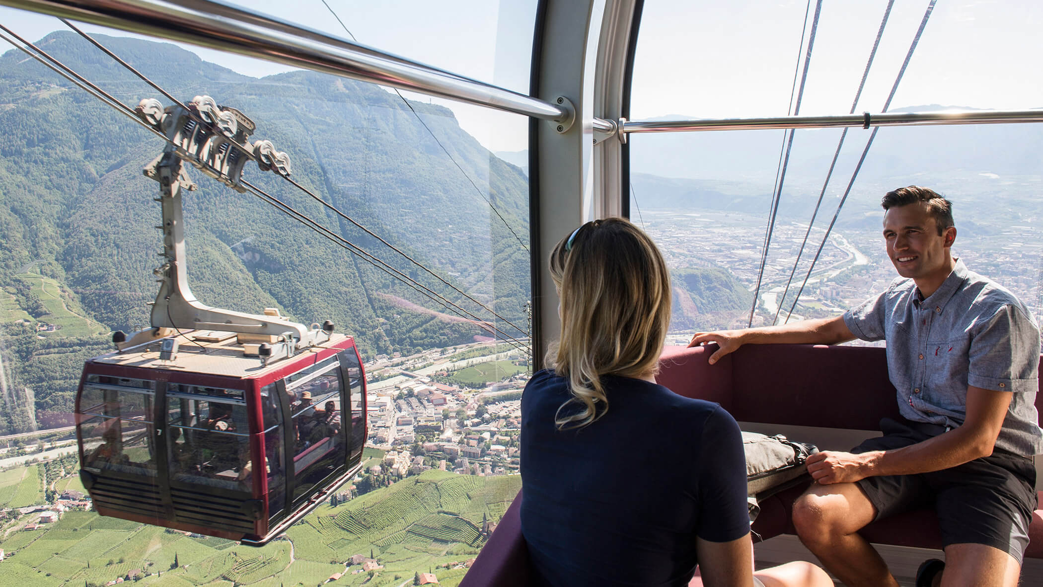 A couple sits in the Renon Railway and rides down the valley - OLM Nature Escape