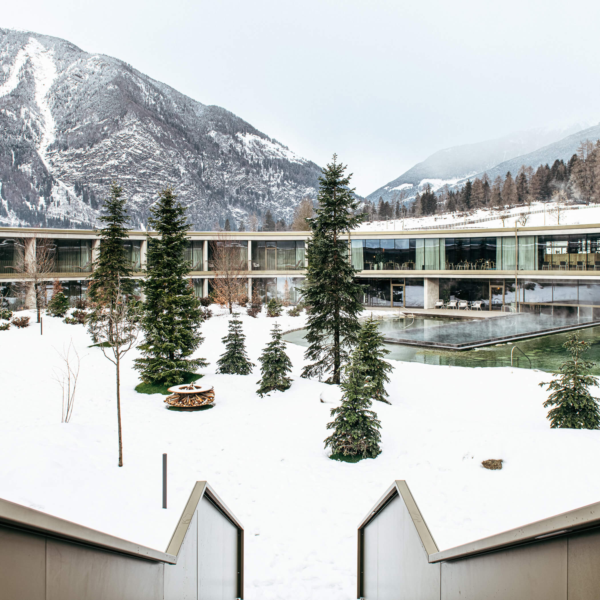 Patio innevato con caminetto e piscina all'aperto riscaldata - OLM Nature Escape