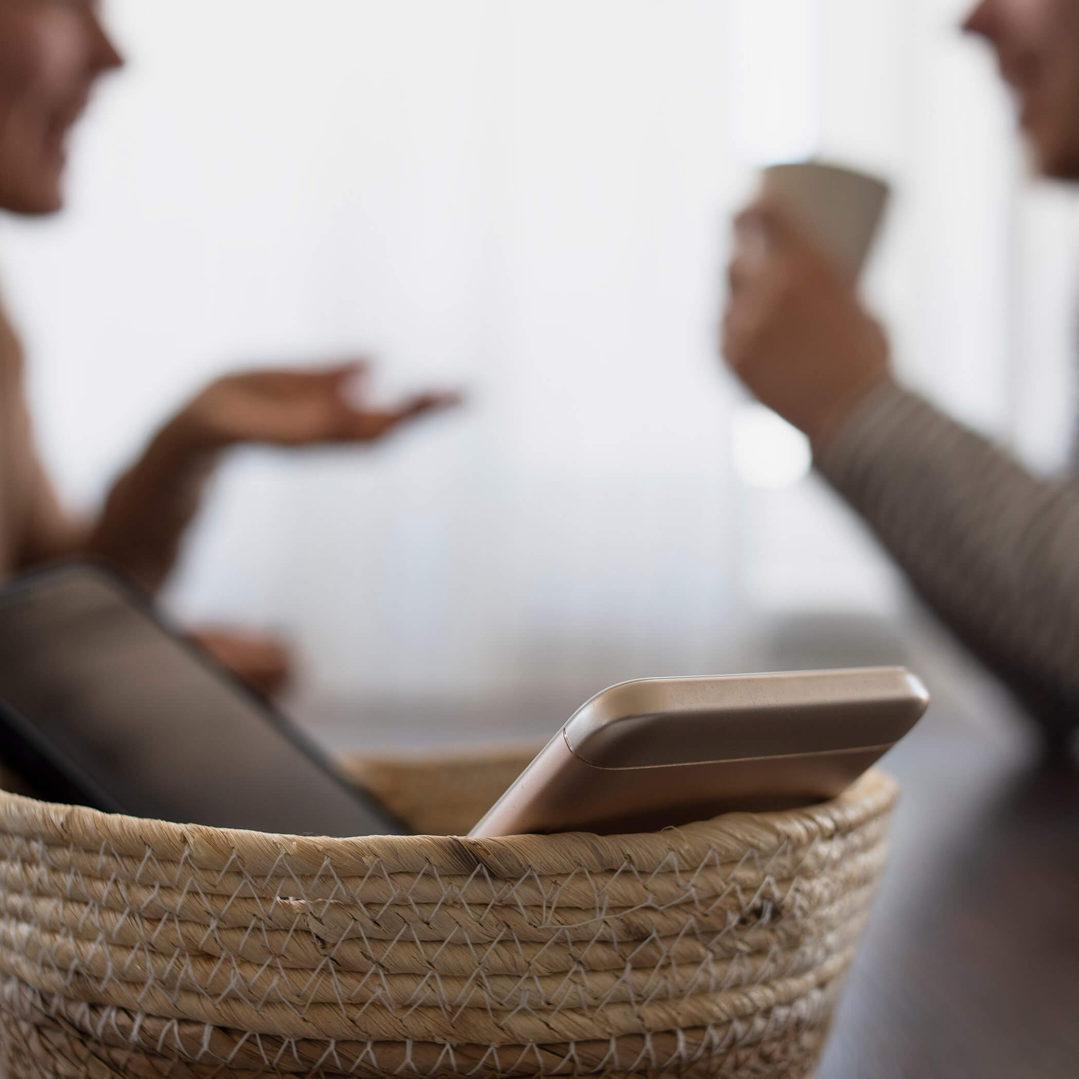 Vacanze senza cellulari - due persone che parlano mentre i loro cellulari sono in un cestino - OLM Nature Escape