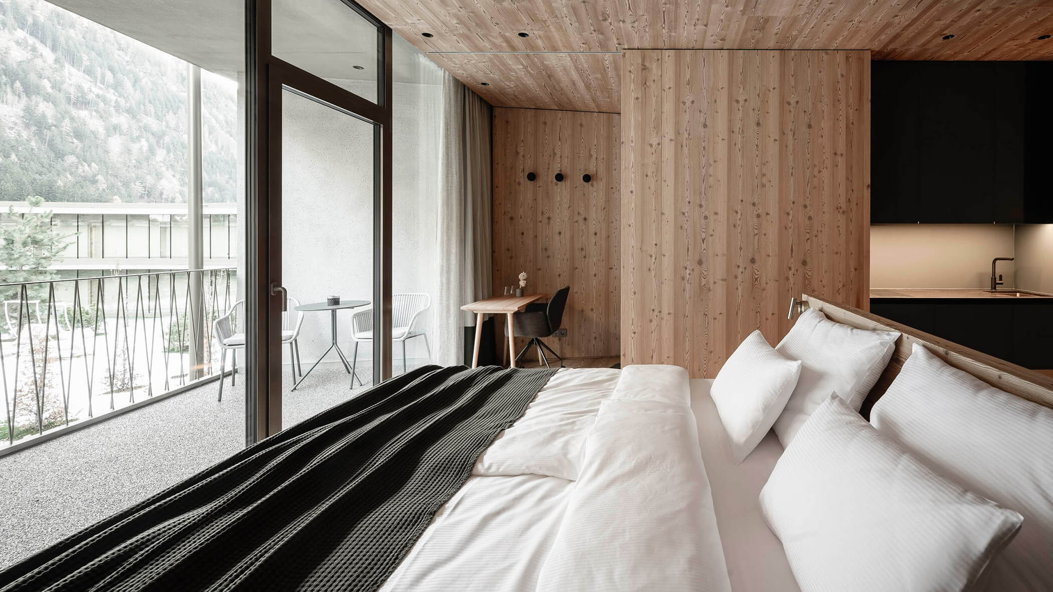 Letto king-size in moderna ApartSuite con vista sul cortile interno - OLM Nature Escape